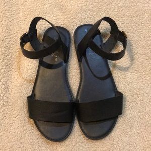 Black strapped sandals .